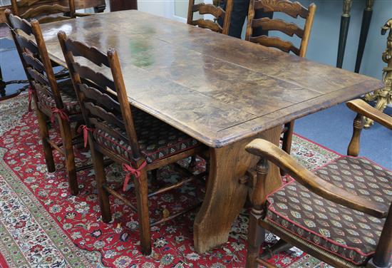 A burr elm planked topped refectory table, on elm trestle end supports W.195cm